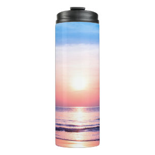 Schöner morgendlicher Sonnenaufgang, blaues Meer, Thermosbecher
