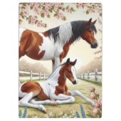Schönes Pferd und Foal im blühenden Obstgarten Klemmbrett (Rückseite)