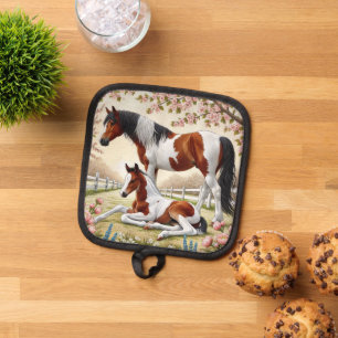 Schönes Pferd und Foal im blühenden Obstgarten Topflappen