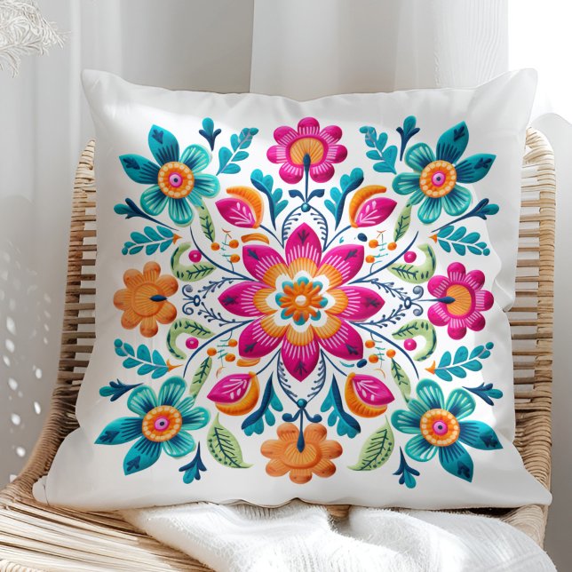 Schönes Rosa Türkis Orange mexikanische Flora Kissen (Beautiful Pink Turquoise Orange Mexican Floral Throw Pillow on a sunny rattan chair.)