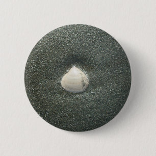 Schönes Seashell im Sand: Ein Salty Souvenir Button
