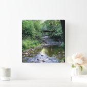 Schönes Sonnenlicht auf dem Wasserbergstrom Quadratische Wanduhr (Zuhause)