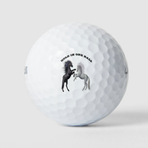 Schwarz und ein weißes Pferd, das kämpft Golfball