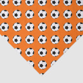 Schwarz-Weiß-Fußball-Bälle auf Orange Seidenpapier (Ausschnitt)