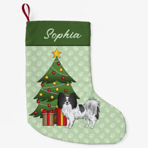 Schwarz-weißer Papillon-Hund an einem Weihnachtsba Kleiner Weihnachtsstrumpf