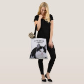 Schwarz-weißes Kätzchen ganz über Tasche (Am Model)