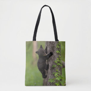 Schwarzbärenjunges klettert auf einen Baum Tasche