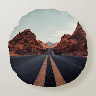 SCHWARZE ASPHALT-STRASSE ZWISCHEN BROWN ROCK FORMA RUNDES KISSEN