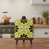 Schwarze Blume auf dem grünen Hintergrund Fliese