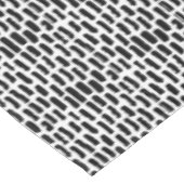 Schwarze Bürste streicht Muster Tischdecke (Schrägansicht)