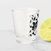 Schwarze Graduierungsklappen in der Luft auf Weiß Schnapsglas (Links)