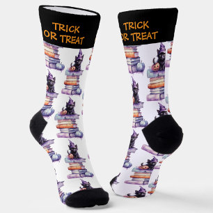 Schwarze Katze mit Kürbis auf einem Stapel Bücher Socken