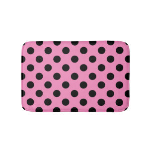 Schwarze Polka-Punkte auf Rosa Badematte