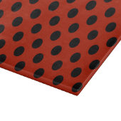 Schwarze Polka Punkte auf rot Schneidebrett (Ecke)