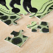 Schwarze Vögel beugen grünes Puzzle (Seite)