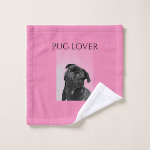 Schwarzer Mops waschen Tuch in rosa.