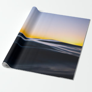 SCHWARZER SAND UNTER ORANGEFARBENEM HIMMEL WÄHREND GESCHENKPAPIER