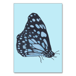 Schwarzer Schmetterling beim Lesen von Taschenkart Tischnummer