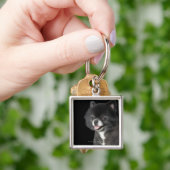 Schwarzer Spitz, der zu dem links schaut Schlüsselanhänger (Hand)