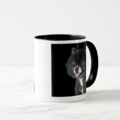 Schwarzer Spitz, der zu dem links schaut Tasse (VorderseiteRechts)