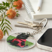 Schwarzer Spitz-Welpe, der Kamera betrachtet Schlüsselanhänger (Vorderseite rechts)