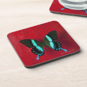 Schwarzer und blauer Schmetterling auf roter Wand Untersetzer (Linke Seite)