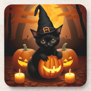 Schwarzes Kätzchen in Hexenhut zwischen Halloween- Getränkeuntersetzer