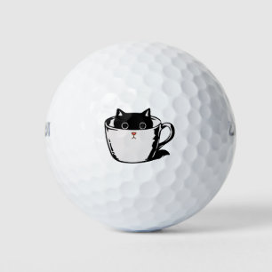 Schwarzes Kätzchen mit roter Nase, das sich in ein Golfball