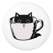 Schwarzes Kätzchen mit roter Nase, das sich in ein Keramikknauf (Vorderseite)