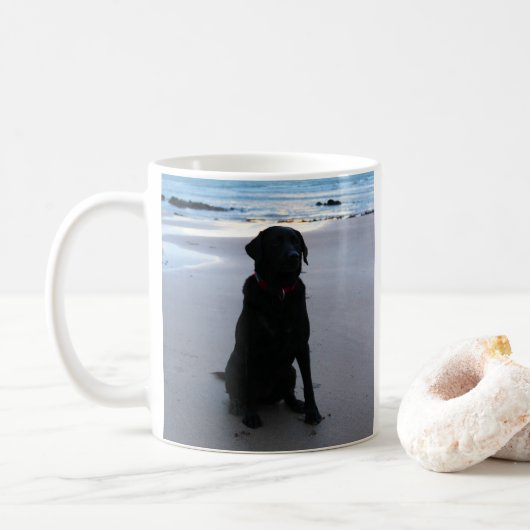 Schwarzes Labrador auf einem Strand Kaffeetasse (Mit Donut)