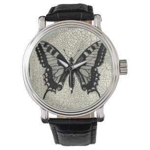 Schwarzweiss-Schmetterling auf gebrochenem Armbanduhr
