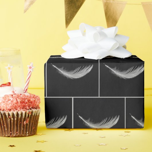 Schwebende weiße Feder auf Schwarz Geschenkpapier (Geburtstagsparty)