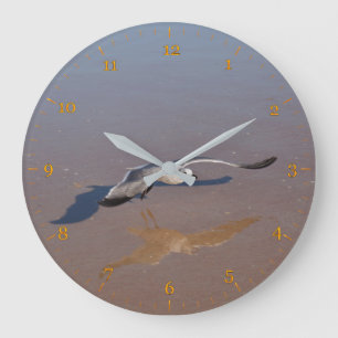 Seagulls reflektieren und schatten auf dem Strand Große Wanduhr