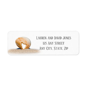 Seashell mit einem Herz auf Sand am Strand,