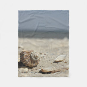 Seashells auf Sand durch das Meer Fleecedecke