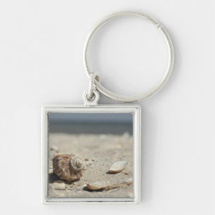 Seashells auf Sand durch das Meer Schlüsselanhänger