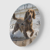 "Seaside Fun: A Cocker Spaniel Play in the Ocean Große Wanduhr (Winkel)