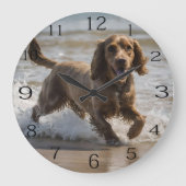 "Seaside Fun: A Cocker Spaniel Play in the Ocean Große Wanduhr (Vorderseite)