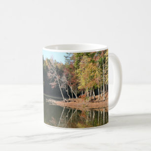 See im See mit orangefarbenen Herbstblättern und b Kaffeetasse