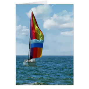 Segelboot mit Regenbogenspinnaker auf Wasser