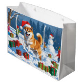 Shiba Inu läuft im Schnee mit Weihnachtsmütze Große Geschenktüte (Rückseite Schrägansicht)