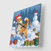 Shiba Inu läuft im Schnee mit Weihnachtsmütze Quadratische Wanduhr (Winkel)