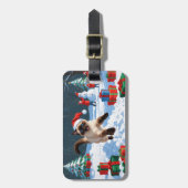 Siamische Katze läuft im Schnee mit Weihnachtsmütz Gepäckanhänger (Vorderseite vertikal)