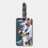 Siamische Katze läuft im Schnee mit Weihnachtsmütz Gepäckanhänger (Rückseite vertikal)