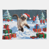 Siamische Katze läuft im Schnee mit Weihnachtsmütz Geschirrtuch (Horizontal)