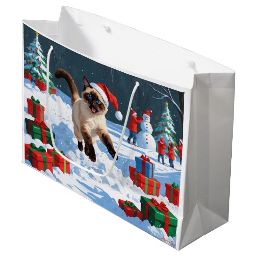 Siamische Katze läuft im Schnee mit Weihnachtsmütz Große Geschenktüte (Vorderseite Schrägansicht)