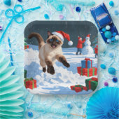 Siamische Katze läuft im Schnee mit Weihnachtsmütz Pappteller (Party)