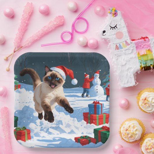 Siamische Katze läuft im Schnee mit Weihnachtsmütz Pappteller (Party)