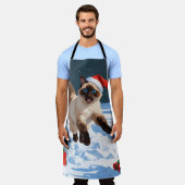 Siamische Katze läuft im Schnee mit Weihnachtsmütz Schürze (Getragen)