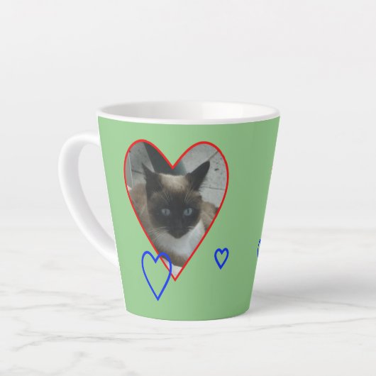 Siamkatze in Herzkruste. Grüne Latte-Tasse Milchtasse (Linke Ecke)
